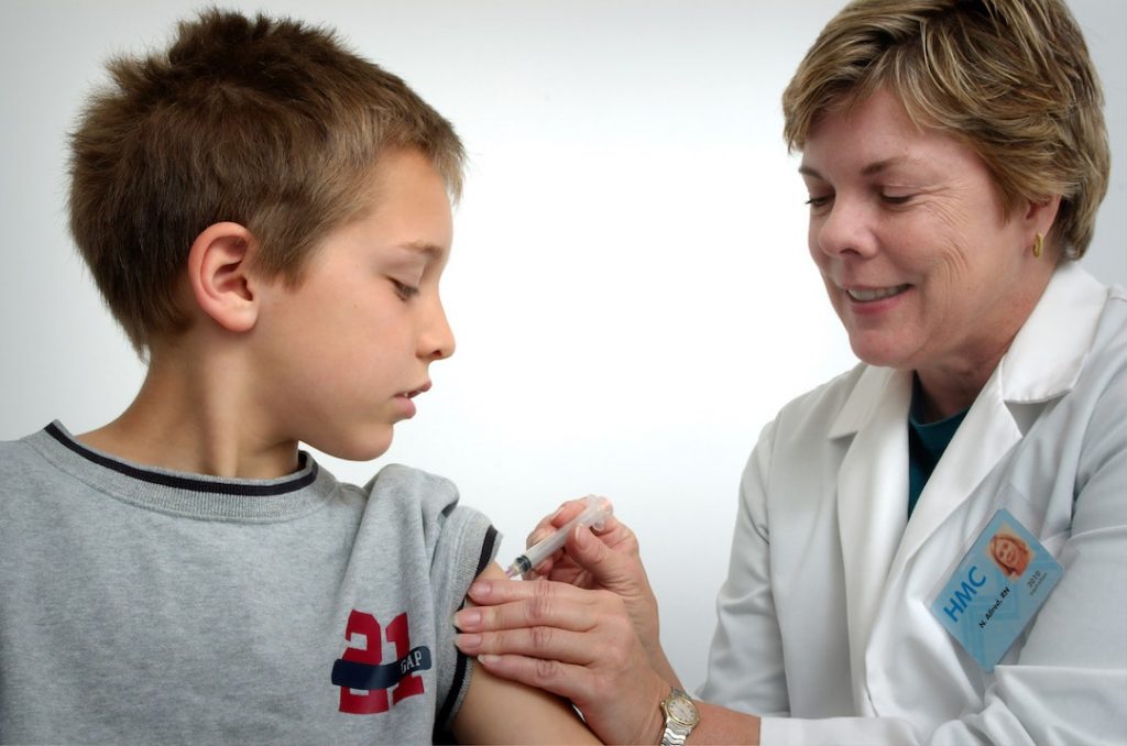 Boy getting a shot from doctor