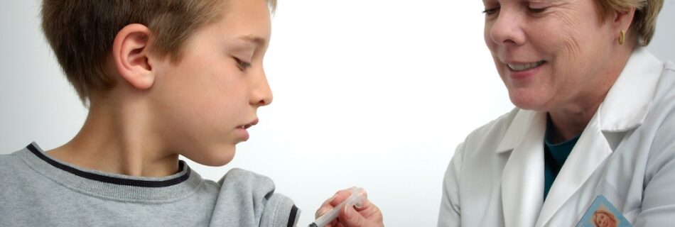 Boy getting a shot from doctor